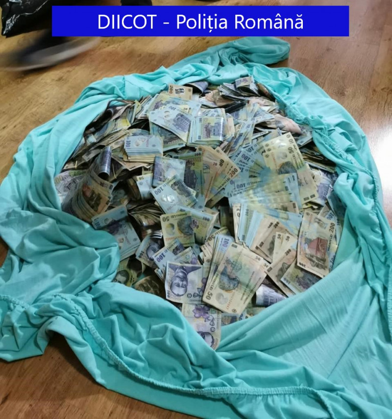 Milioane de lei ascunși în cutii și la saltea, în casa unui traficant de droguri din București